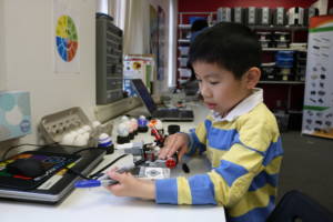 Boy working with robots during Robotics Week at Empow Studios