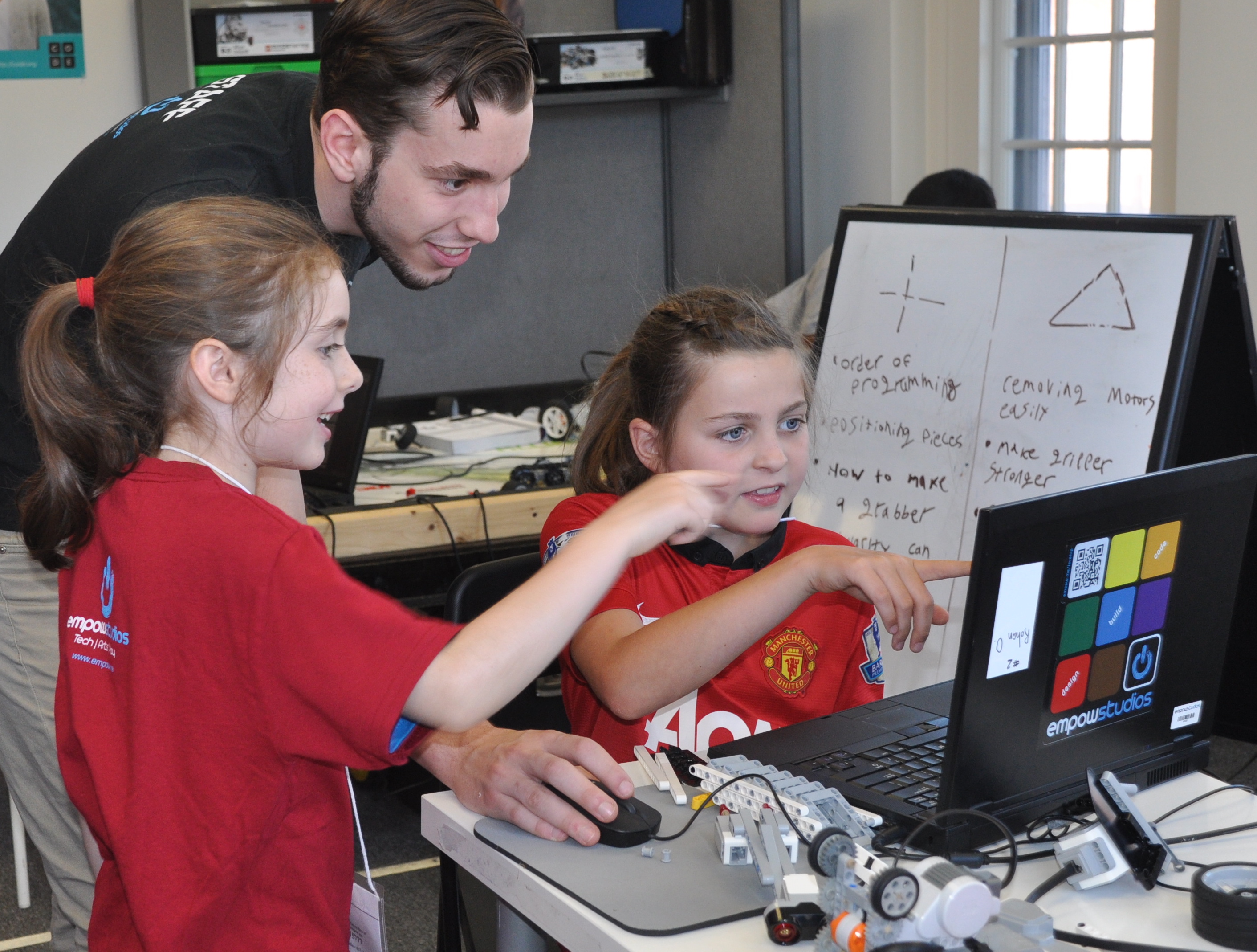 Robotics students working with Empow Studios STEM Teacher